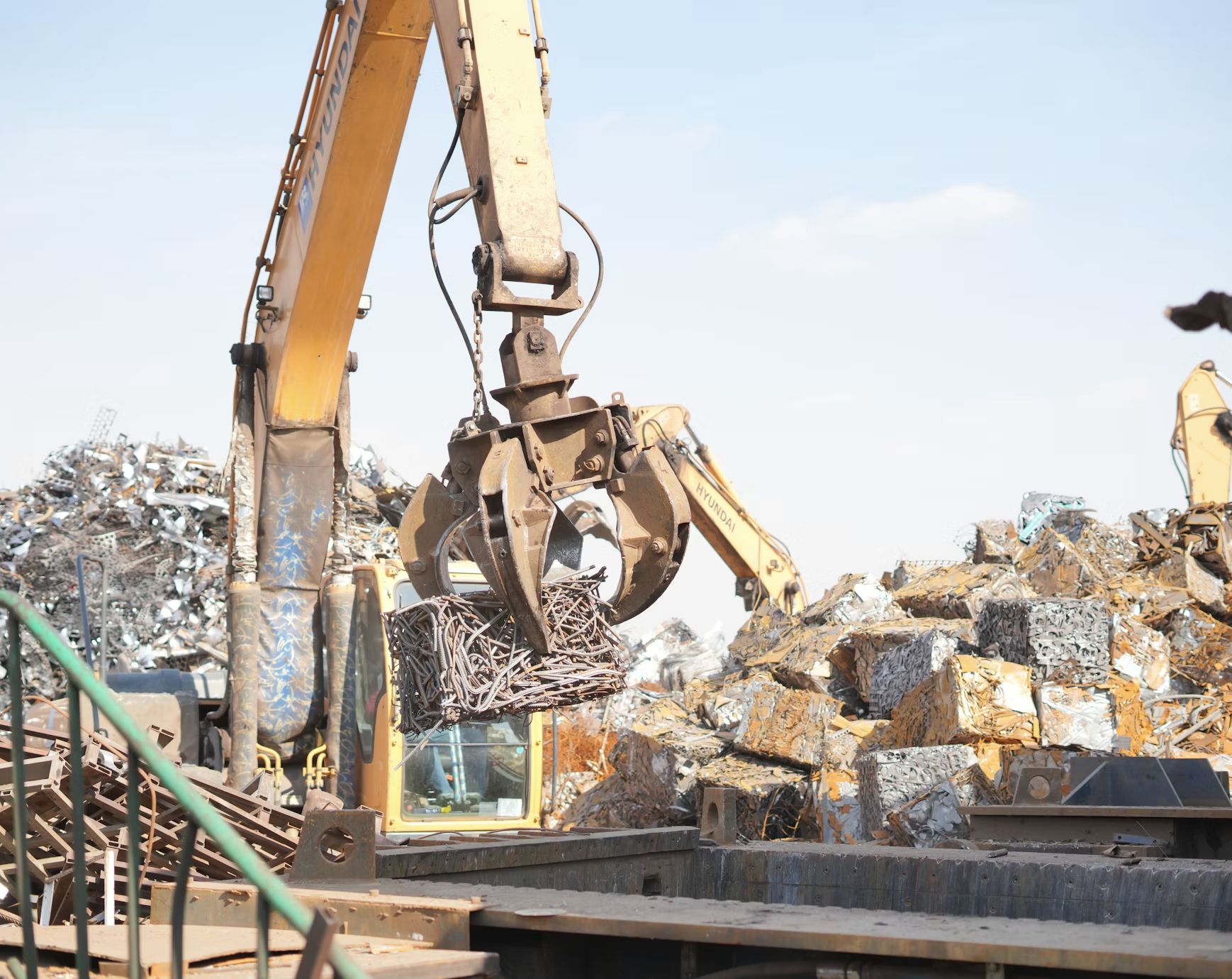 Grab crane lifting a bale of scrap metal in a recycling yard